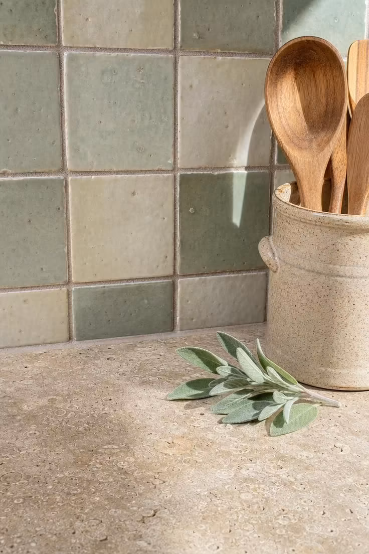 13 Charming Rustic Cottage Ideas for a Welcoming Retreat 8 Rough limestone counter meeting hand-thrown ceramic backsplash tiles in celadon and cream.