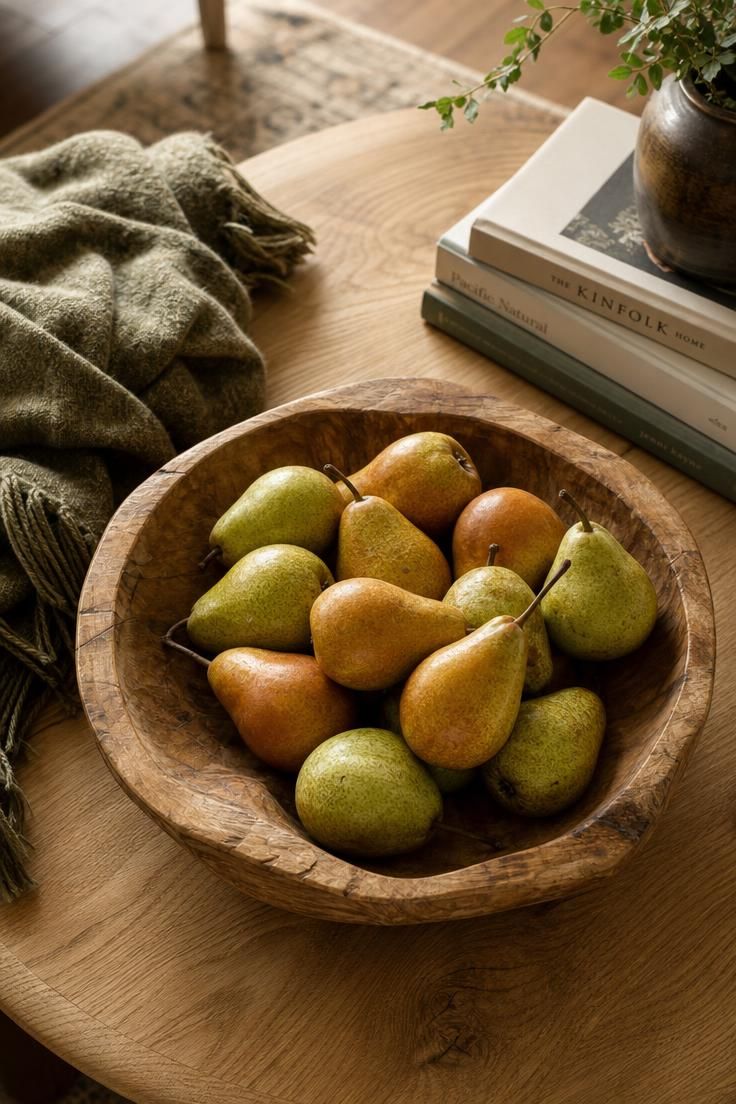 A low wooden bowl of green and amber pears as a simple autumn table centerpiece.