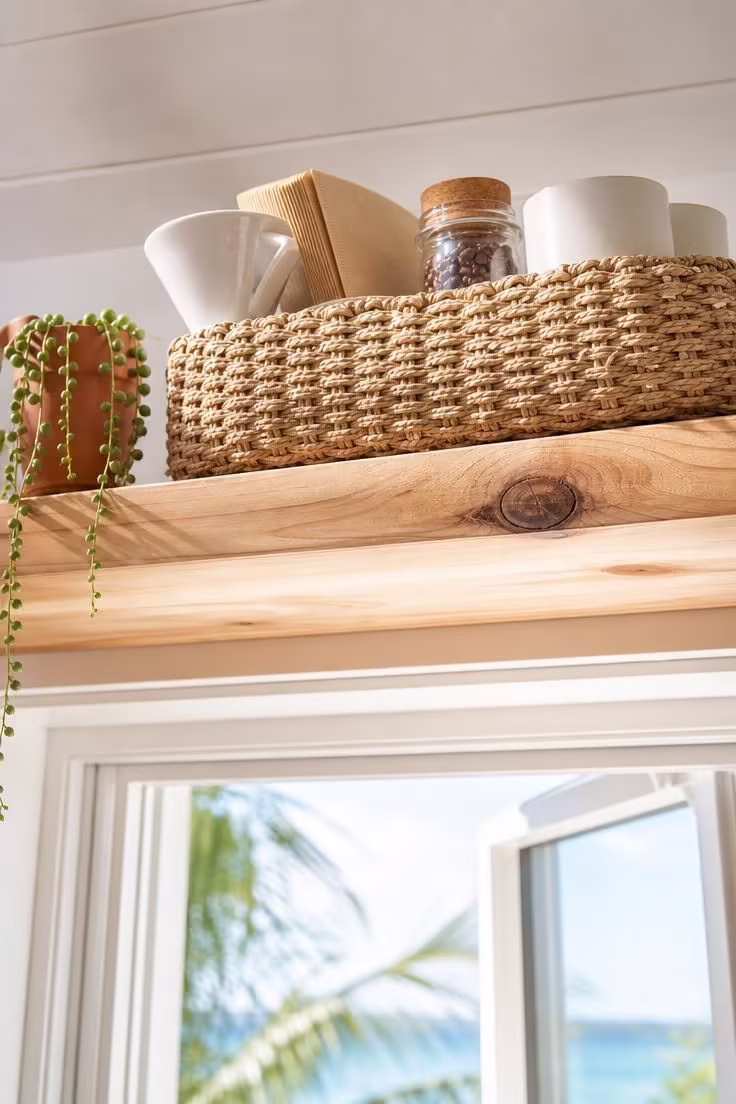 13 Charming Small Coffee Bar Ideas You Can Copy Today 13 Woven seagrass basket caddy on a raw cedar floating shelf above a kitchen window in bright midday sun