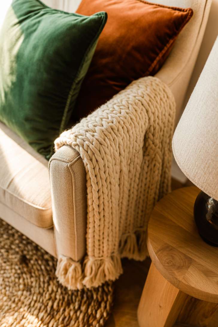 Layered textures in cozy library including knit blankets and varied fabrics