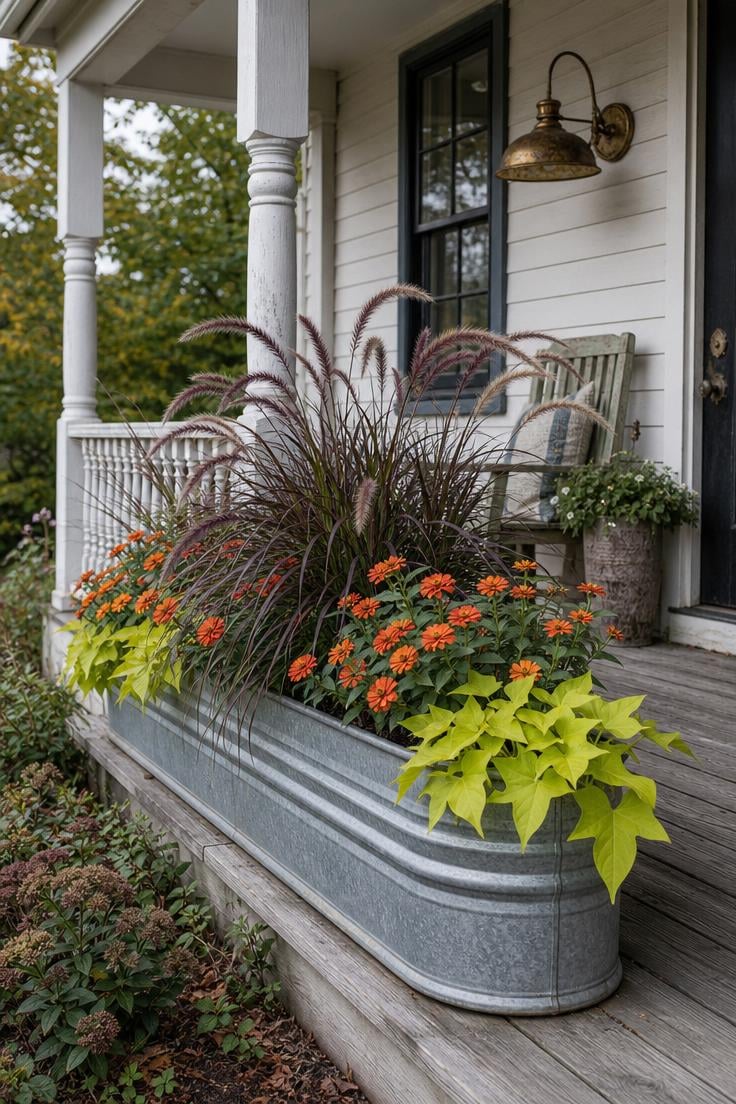 13 Summer Front Porch Decor Ideas That Will Stop Traffic 7 Galvanized metal trough planter with ornamental grass and orange zinnia on a summer front porch