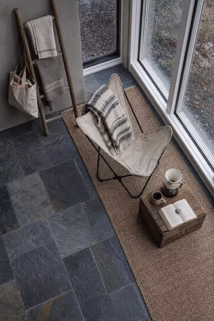 11 Cozy Sunroom Reading Nook Ideas for Book Lovers 9 Slate tile floor with jute runner and canvas butterfly chair in a sunroom reading nook