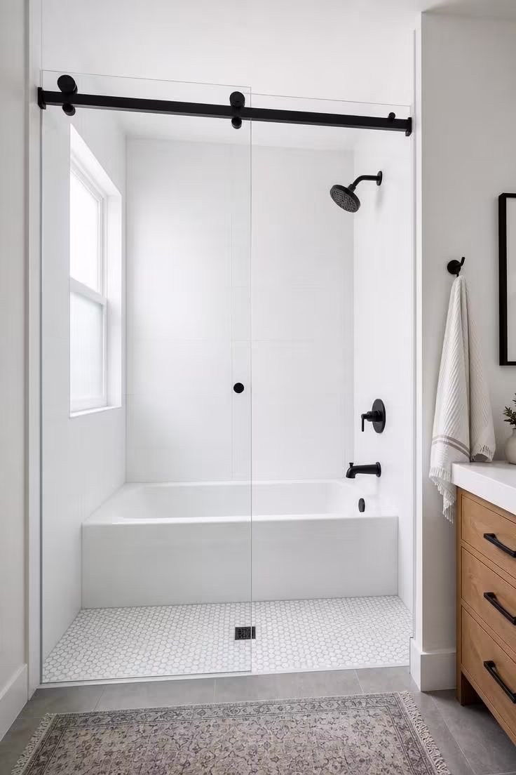 13 Cozy Tiny Bathroom Ideas With Bathtub Worth Copying 7 Shower-tub combo with frameless sliding glass door and penny round floor tile in a bright tiny bathroom