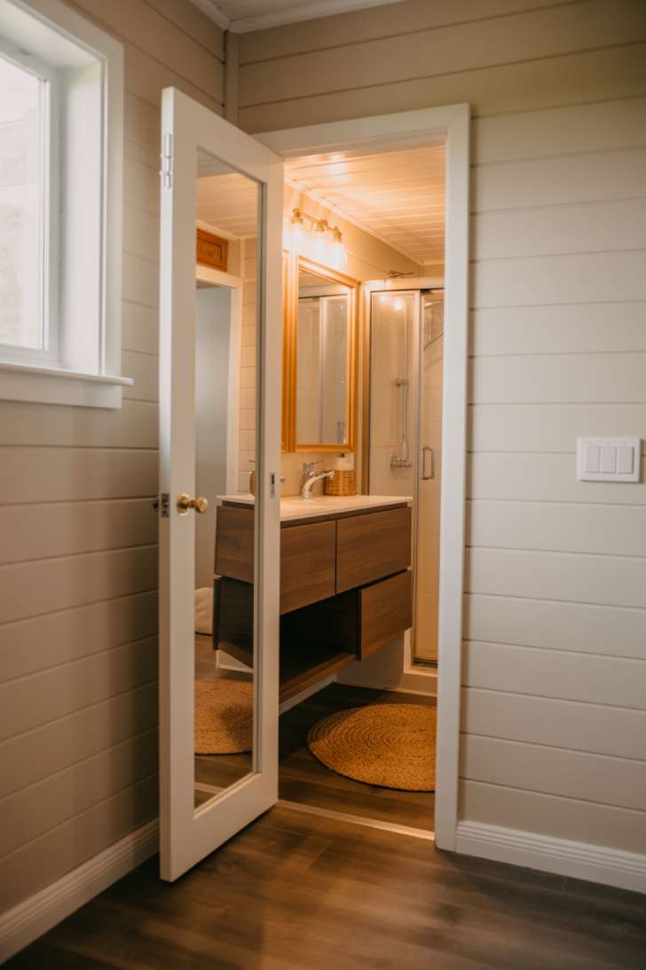 13 Smart Tiny House Bathroom Ideas for Tiny Budgets 4 Pocket door with full-length mirror inside a tiny house bathroom