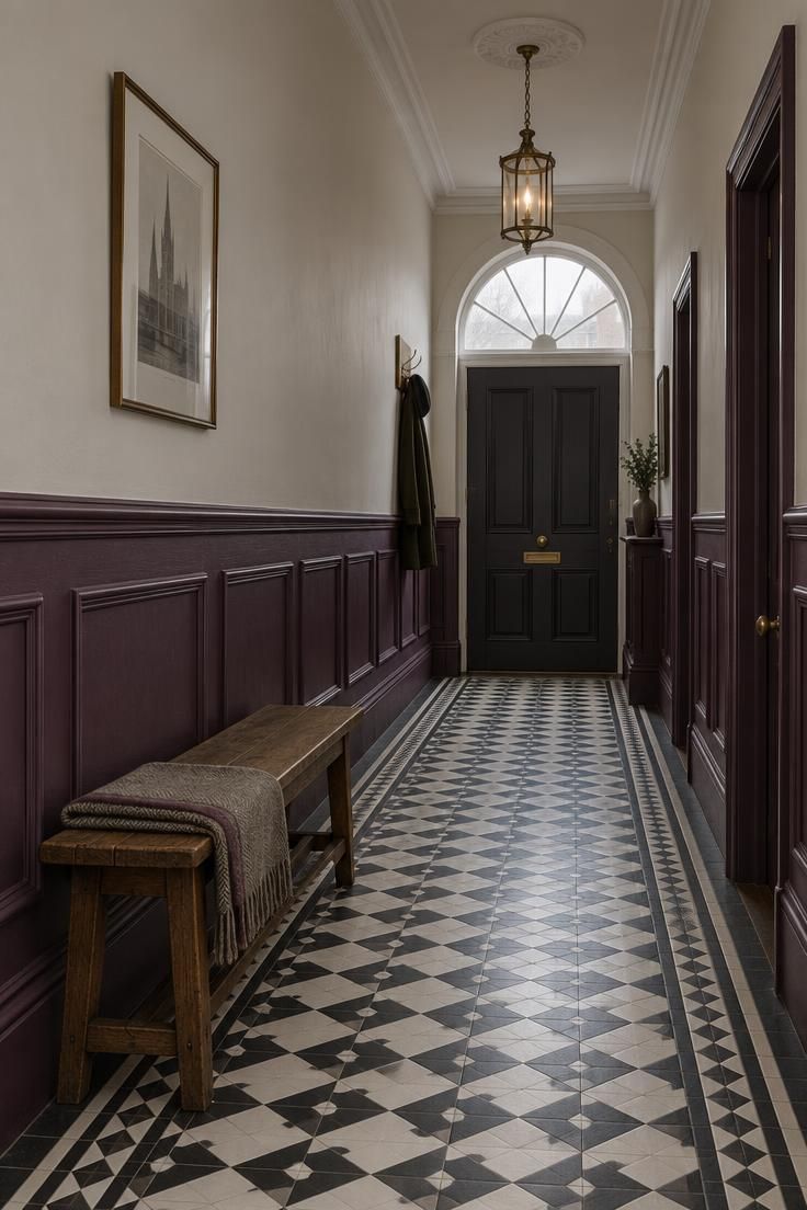 Long Victorian hallway with off-white upper walls, dark plum panelling below a dado rail, black and white tile floor, and wooden bench.
