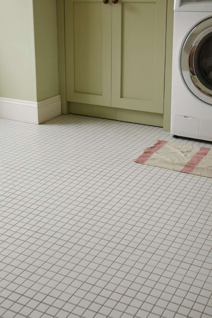 12 Timeless Vintage Laundry Room Decor Ideas to Steal Now 8 Classic white penny tile floor with ticking stripe cotton rug in front of a sage green shaker cabinet in a vintage laundry room