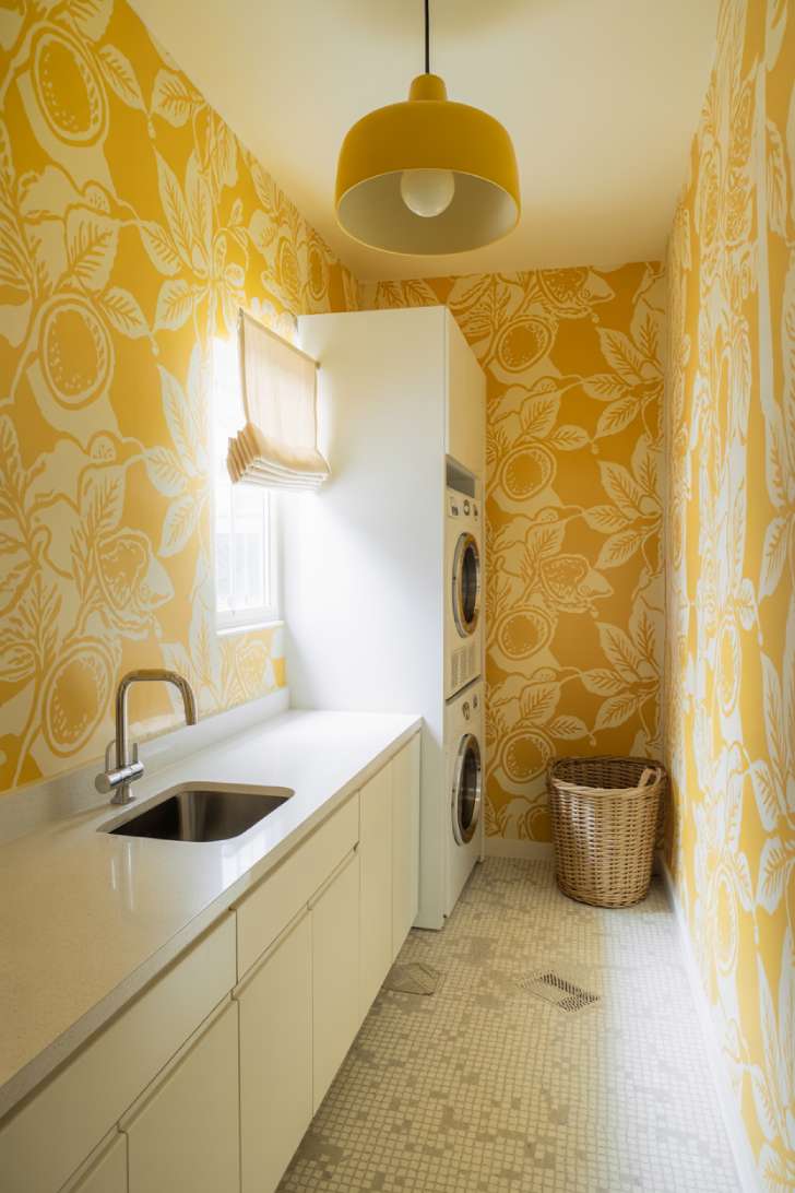 Yellow botanical wallpaper laundry room with white cabinets and polished nickel fixtures